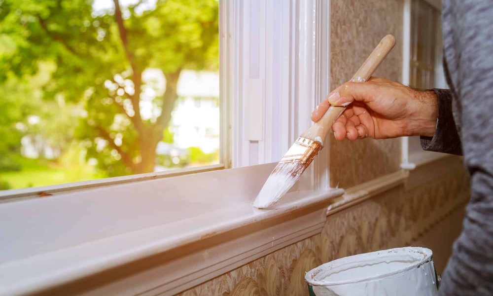 male-hands-repairs-painting-window-trim-at-home-closeup.jpg